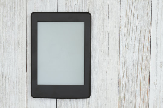 An e-reader on a weathered desk