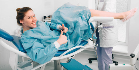 Positive woman during examination by a gynecologist. Having advise with her gynecologist.