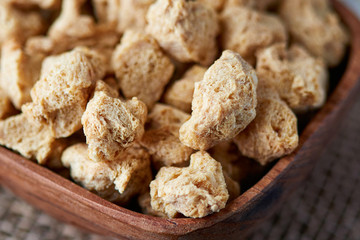 Raw soya chunks, soy meat for vegans in wooden bowl