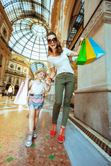 mother and daughter travellers with colorful shopping bags