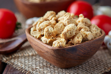 Raw soya chunks, soy meat for vegans in wooden bowl