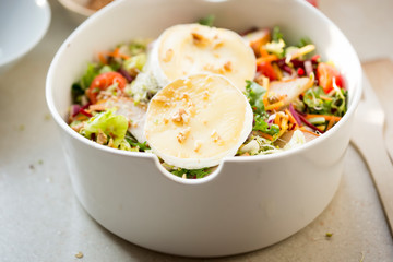 Salad with lettuce,  brie, fried pears, camembert, walnuts, red onion, tomatoes and raspberry vinaigrette dressing