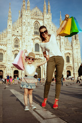 happy trendy mother and daughter with colorful shopping bags