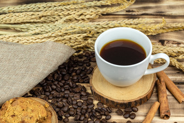 Close up hot coffee with coffee beans on wooden table.
