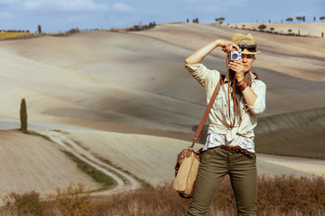 solo traveller woman taking photos with retro photo camera