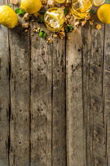 Lemonade or iced summer tea, with fresh lemon slices, sugar and mint leaf, rustic wooden table, copy space