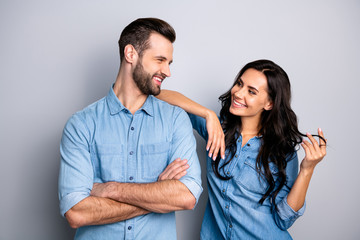 Portrait of cute pleasant adorable guy lady trying to go on date touching shoulder curls by hand fingers looking tender gentle wearing denim outfit on argent background