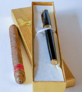 Caja de regalo con una pluma estilogr&aacute;fica junto a un cigarro.