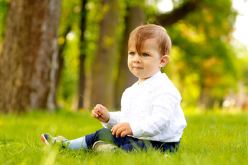 Portrait of beautiful smiling cute baby boy in park