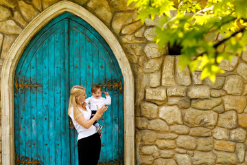 Mother and his boy posing in front of old blue door