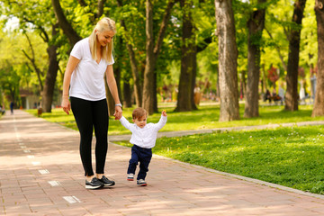 Beautiful mother and his son walking in park and having a good time together