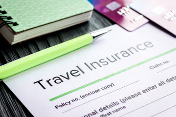 Traveling concept with insurance application on wooden table