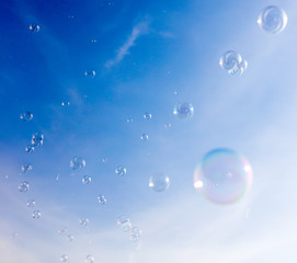 Soap bubbles fly in the blue sky