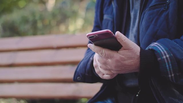 Charismatic senior tries to take photos on smartphone on street