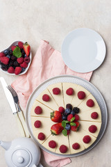 Close up holiday cake with berries, plate, fork and knife on white background