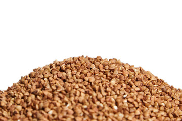 Heap of buckwheat grains. Dry brown kernel on white background. Selective focus