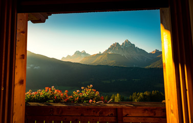 splendid view of Dolomites mountains from a window of a wooden cottage. South Tyrol, Italy