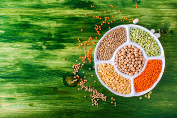 Assortment of legumes bowls and various spices top view - Healthy food background flat lay of green...