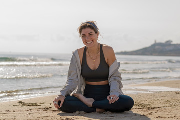 Naklejka na ściany i meble beautiful woman doing yoga and meditating on the seashore