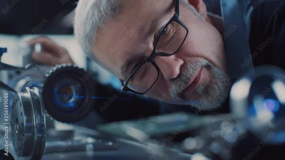 Aufkleber close-up portrait of focused middle aged engineer in glasses working with high precision laser equip