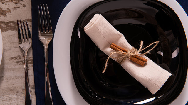 Rustic table setting with pink flowers and candle on light wooden table. Holidays decoration on Provence style. Romantic dinner. Overhead