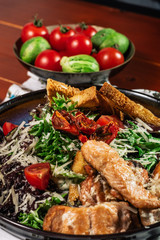 Caesar salad with salmon. Served with white wine. Salad with red fish fillet, cesar sauce, croutons, lettuce, cherry tomato, close up.