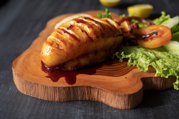 Fried squid on a wooden board with vegetables