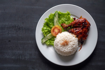 Grilled chicken leg with rice on a plate