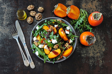 Salad with persimmon, arugula, white cheese and nuts. Keto diet. Keto lunch idea. Pegan diet.