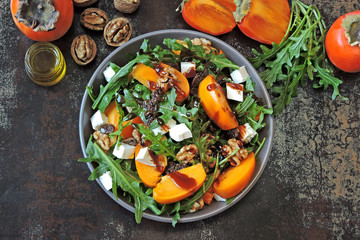 Salad with persimmon, arugula, white cheese and nuts. Keto diet. Keto lunch idea. Pegan diet.