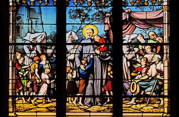 Saint Vincent de Paul gathering with the Daughters of Charity abandoned children, stained glass window in Saint Severin church in Paris, France