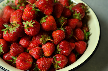 A metal bowl full of fresh strawberries