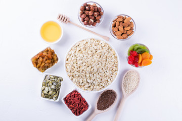 Oat flakes and various delicious ingredients for healthy breakfast, top view,