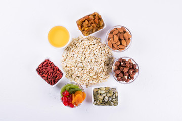 Oat flakes and various delicious ingredients for healthy breakfast, top view,