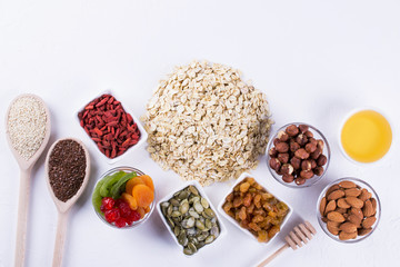 Ingredients for homemade oatmeal granola. Oat flakes, honey, nuts, dried fruit and seeds. Healthy breakfast concept.