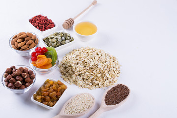 Ingredients for homemade oatmeal granola. Oat flakes, honey, nuts, dried fruit and seeds. Healthy breakfast concept.