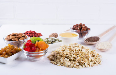 Ingredients for homemade oatmeal granola. Oat flakes, honey, nuts, dried fruit and seeds. Healthy breakfast concept.