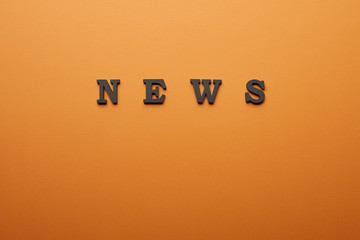 top view of news lettering with copy space on orange