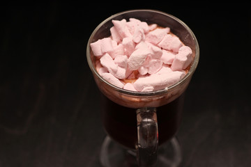 hot drink in a glass cup with pink marshmallows and white box with a transparent cover in the form of heart with cookies