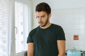 Young man looking at the camera in surprise.