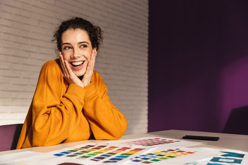 Cheerful artistic woman choosing paint color on a palette