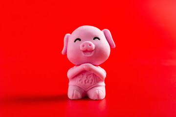 a pink cute pig mascot for the new year 2019 on red background translation for the Chinese in...
