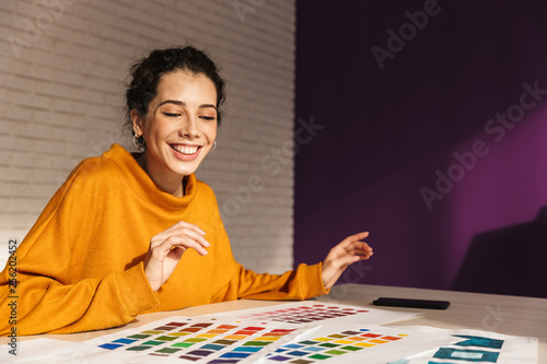 Cheerful artistic woman choosing paint color on a palette