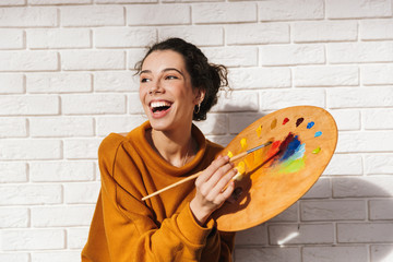 Lovely artistic woman holding color palette for painting