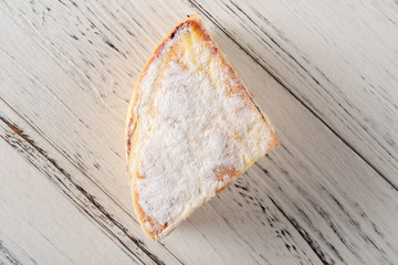 top view slice of cake on white wood background