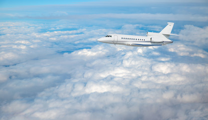 Fototapeta premium Luksusowy prywatny odrzutowiec latający nad chmurami i morzem