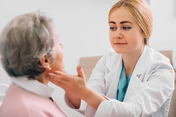 otolaryngologist examining senior patient's at medical office