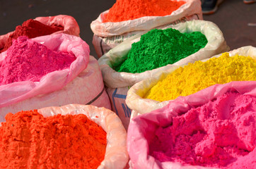 gunny bags of different colored herbal organic colors gulal on display in old delhi for holi celebration