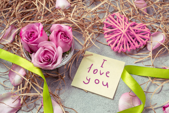 pink roses, a heart and a note with the inscription I love you on the table-the concept of love and care