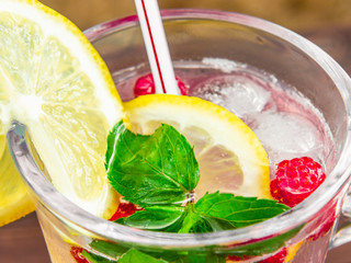Refreshing summer cocktail with lemon, raspberry and mint close-up